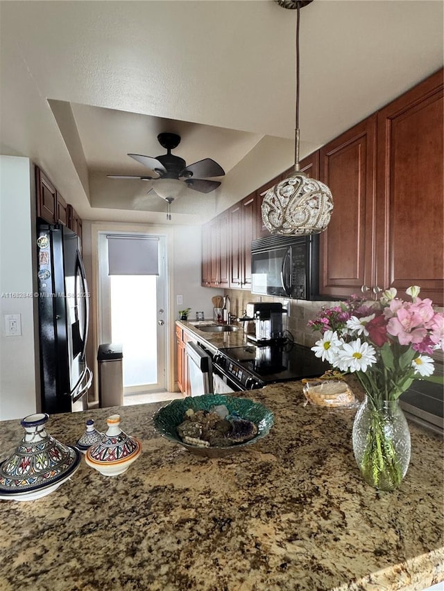 kitchen with black appliances, tasteful backsplash, stone counters, and a sink