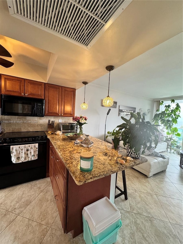 kitchen featuring tasteful backsplash, brown cabinetry, light stone countertops, a peninsula, and black appliances