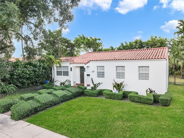 mediterranean / spanish home featuring a front lawn