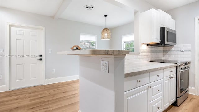 kitchen with appliances with stainless steel finishes, white cabinetry, and light hardwood / wood-style flooring