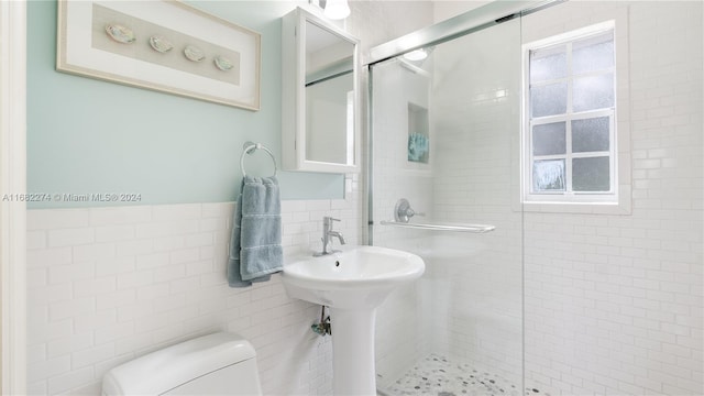 bathroom featuring tile walls, toilet, and an enclosed shower