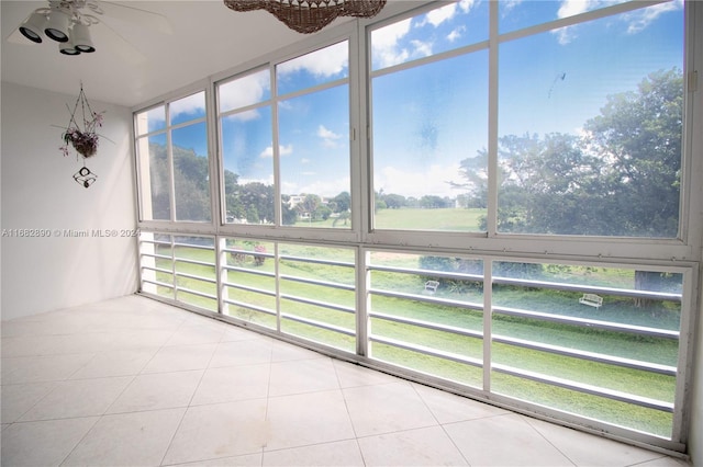 unfurnished sunroom with ceiling fan