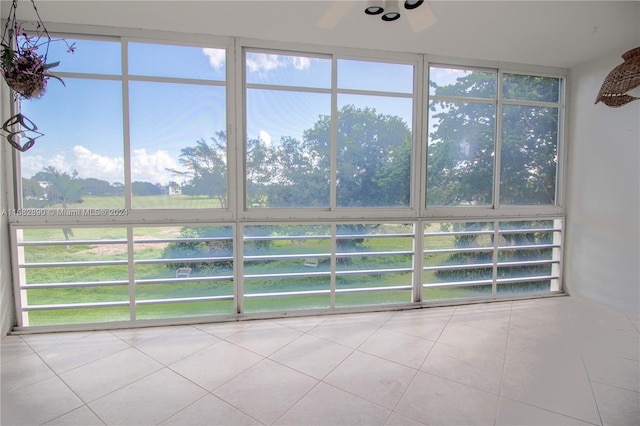 unfurnished sunroom featuring ceiling fan