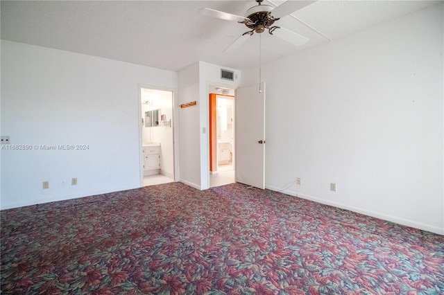 unfurnished bedroom with carpet, ceiling fan, ensuite bathroom, and a textured ceiling