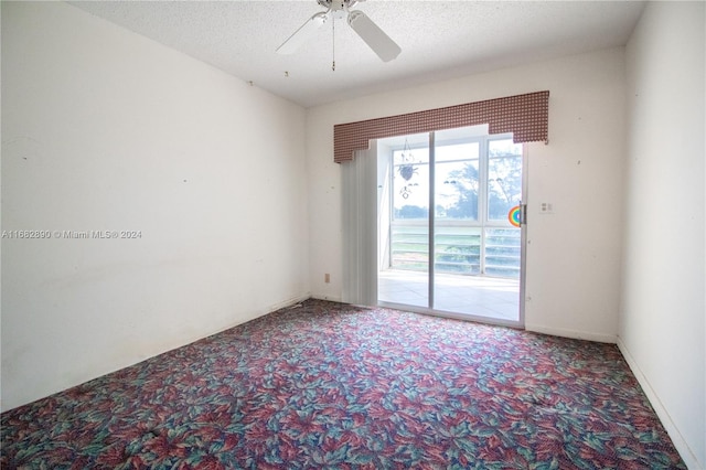 carpeted spare room with a textured ceiling and ceiling fan