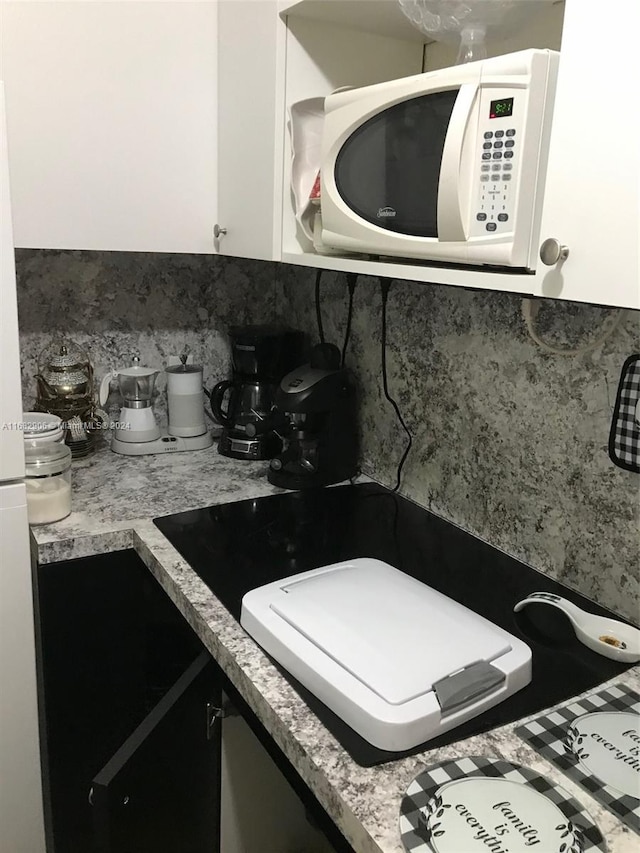 kitchen featuring decorative backsplash and white cabinets