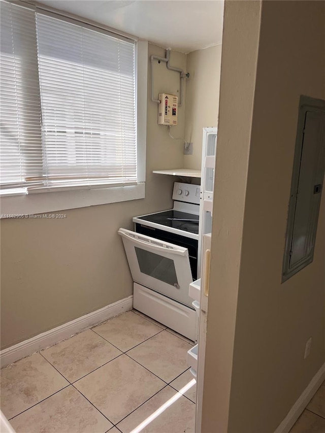 kitchen with electric panel, light tile patterned floors, and electric stove