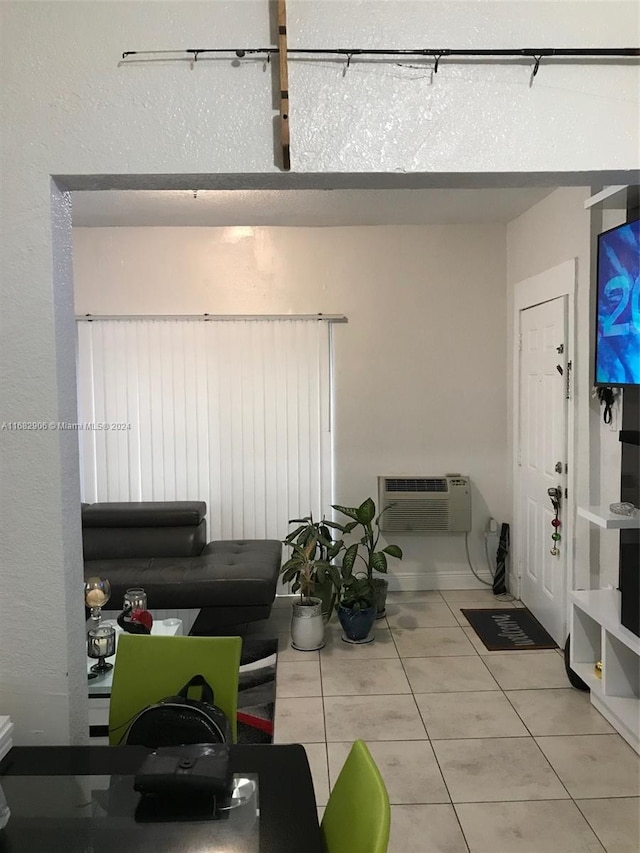 living room featuring tile patterned floors and a wall mounted air conditioner