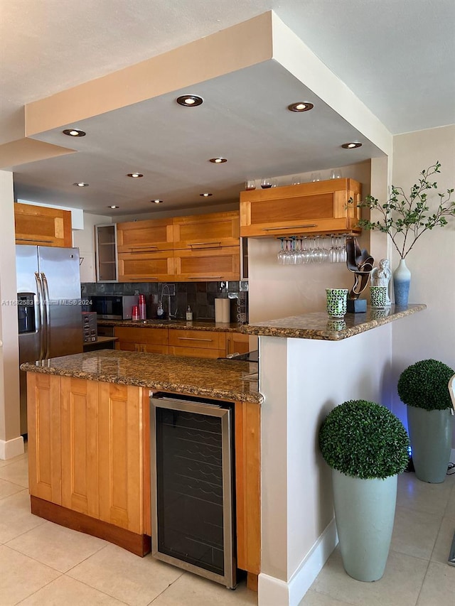 kitchen featuring tasteful backsplash, kitchen peninsula, dark stone counters, beverage cooler, and stainless steel refrigerator with ice dispenser