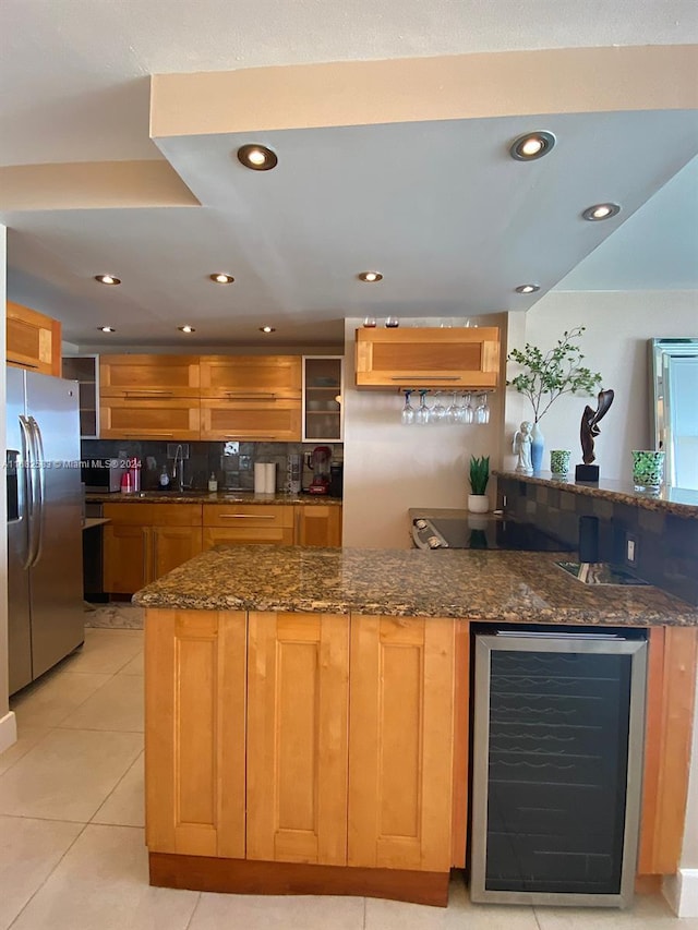 kitchen with stainless steel refrigerator with ice dispenser, kitchen peninsula, dark stone counters, wine cooler, and light tile patterned floors