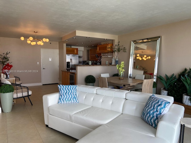 living room with a textured ceiling, light tile patterned floors, a chandelier, and beverage cooler