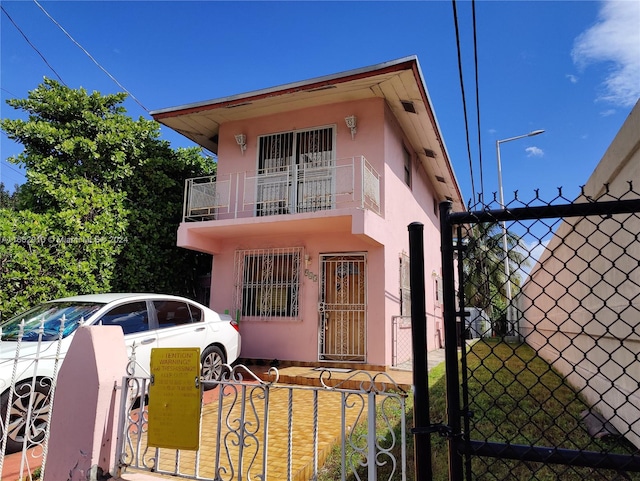 view of front of house featuring a balcony and a front yard