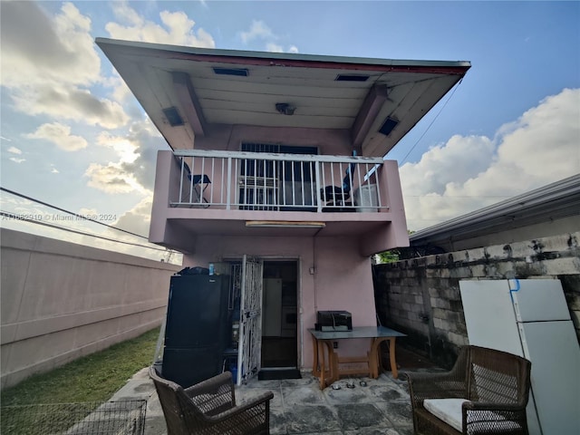 rear view of house with a balcony and a patio area