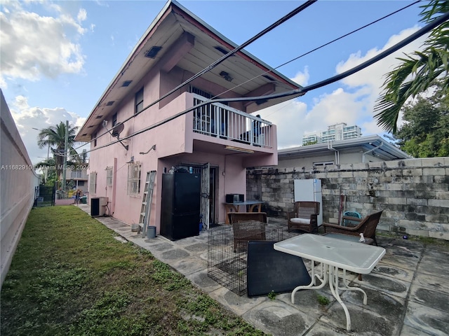 rear view of house featuring a patio area, central AC unit, and a balcony