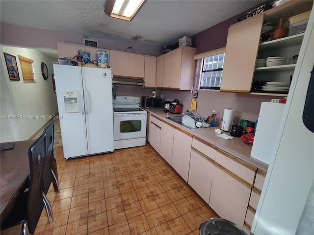 kitchen featuring a textured ceiling, white cabinets, sink, and white appliances