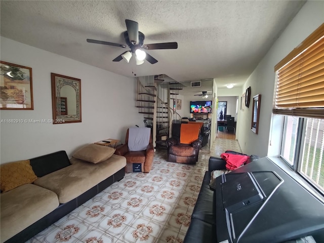 living room featuring a textured ceiling and ceiling fan