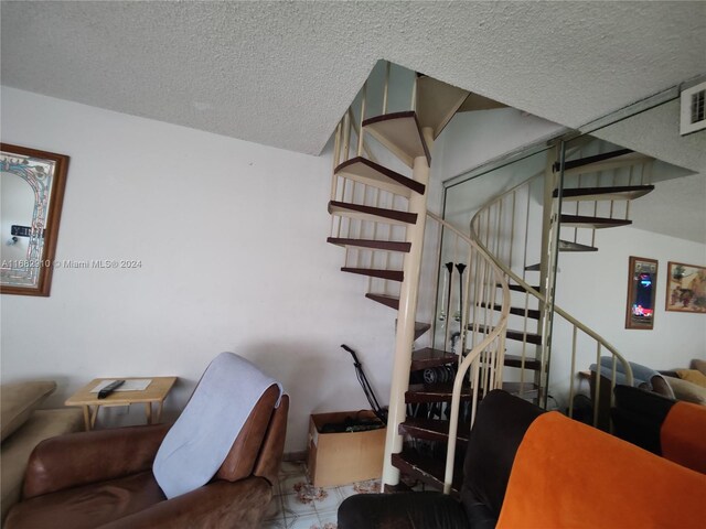 stairway featuring a textured ceiling