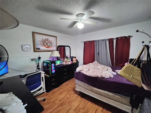 bedroom with light hardwood / wood-style floors, a textured ceiling, and ceiling fan