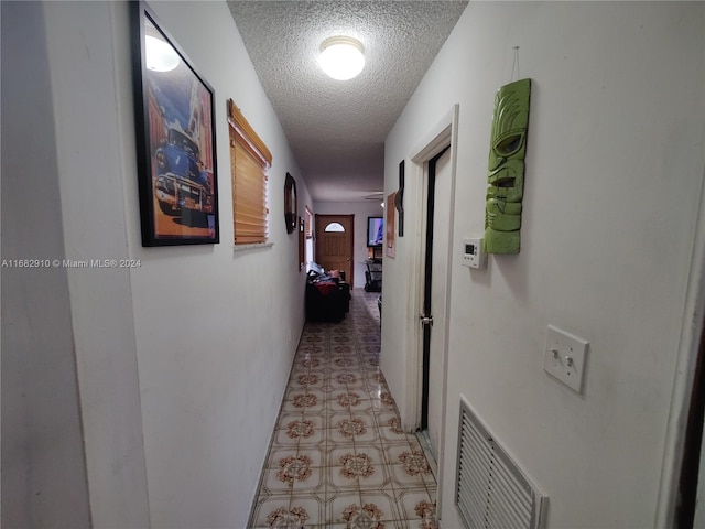 hall with a textured ceiling