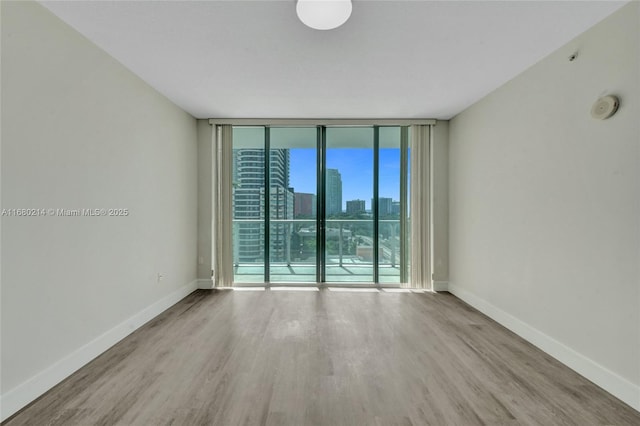 spare room featuring hardwood / wood-style flooring and floor to ceiling windows