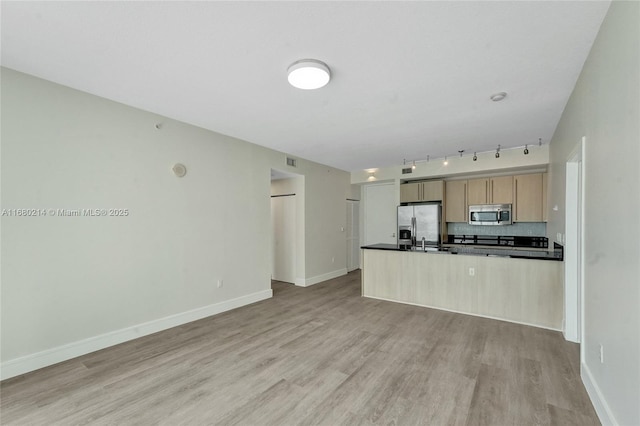 kitchen featuring light brown cabinetry, tasteful backsplash, sink, stainless steel appliances, and light hardwood / wood-style flooring