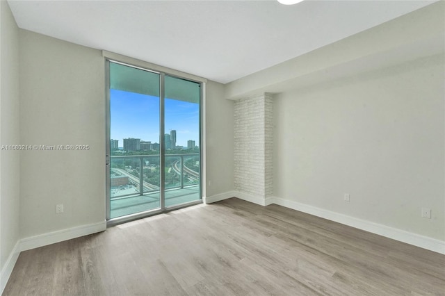 spare room with wood-type flooring and expansive windows