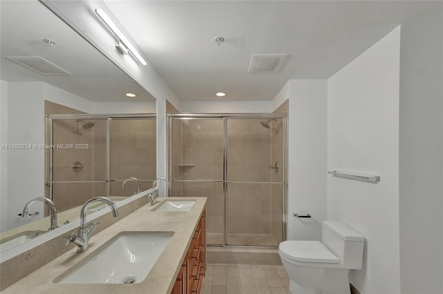 bathroom with vanity, toilet, tile patterned flooring, and a shower with door