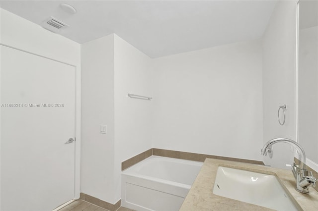 bathroom with tile patterned flooring, vanity, and a bathtub