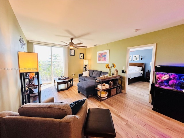 living room with ceiling fan and light hardwood / wood-style flooring