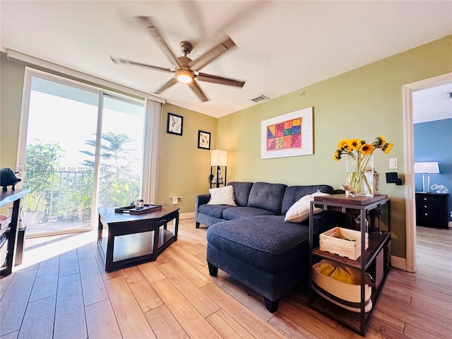 living room featuring ceiling fan and light hardwood / wood-style flooring