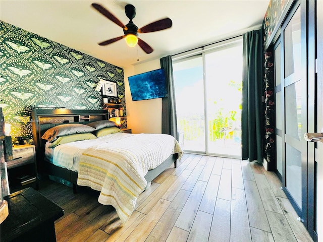 bedroom featuring floor to ceiling windows, wood-type flooring, and ceiling fan