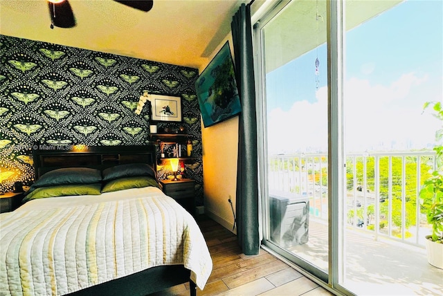 bedroom featuring ceiling fan, wood-type flooring, access to outside, and multiple windows