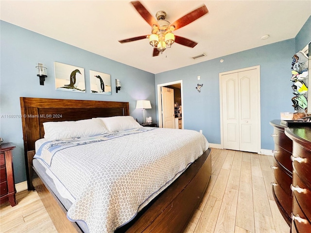 bedroom with light hardwood / wood-style floors, a closet, and ceiling fan