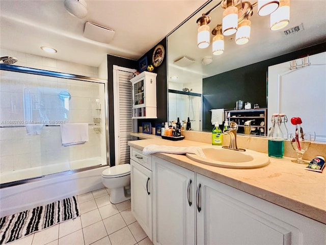 full bathroom featuring tile patterned floors, vanity, toilet, and enclosed tub / shower combo