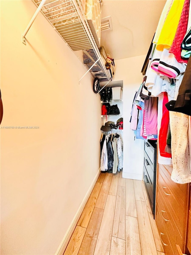 walk in closet with wood-type flooring