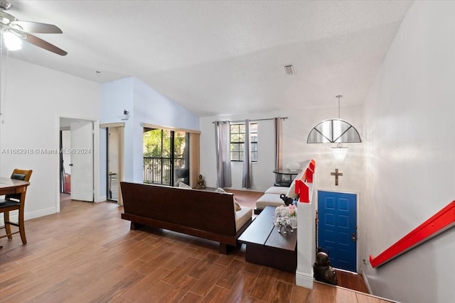 living room featuring lofted ceiling, hardwood / wood-style floors, a textured ceiling, and ceiling fan