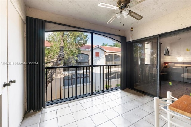 unfurnished sunroom with ceiling fan