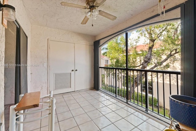 unfurnished sunroom featuring ceiling fan