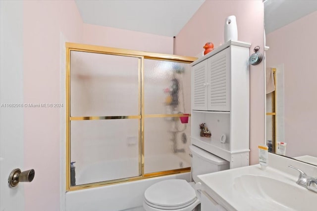 full bathroom featuring toilet, combined bath / shower with glass door, and vanity