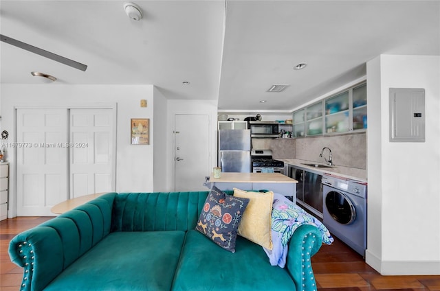 living room with washer / dryer, electric panel, sink, and dark hardwood / wood-style flooring