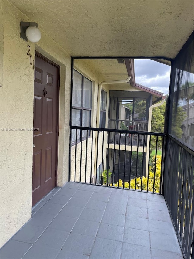 view of exterior entry with a balcony