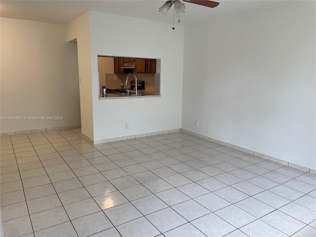 tiled spare room with ceiling fan and sink