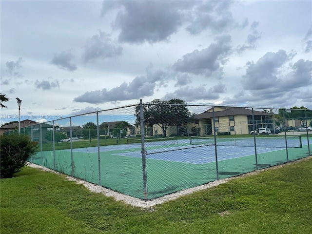 view of sport court with a lawn