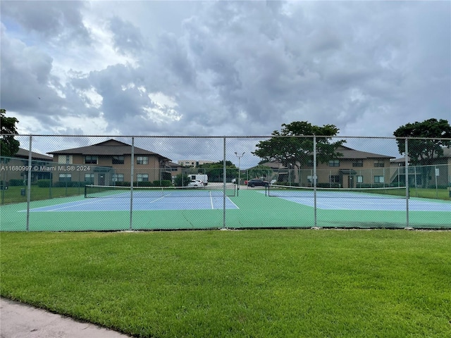 view of tennis court featuring a lawn