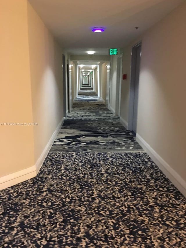 hall featuring dark carpet