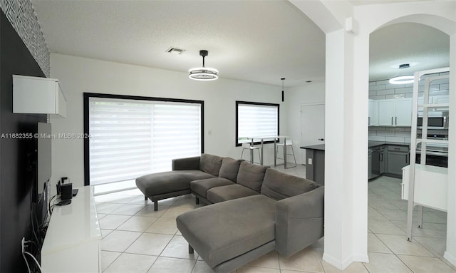 living room with a textured ceiling and light tile patterned flooring