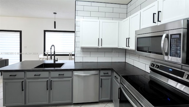 kitchen with a wealth of natural light, sink, appliances with stainless steel finishes, and white cabinets