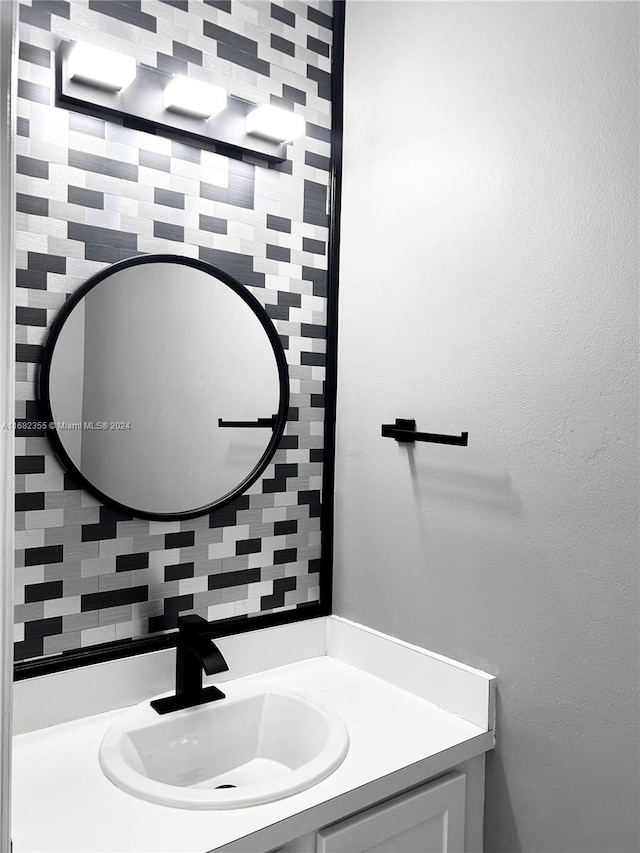 bathroom featuring vanity and backsplash