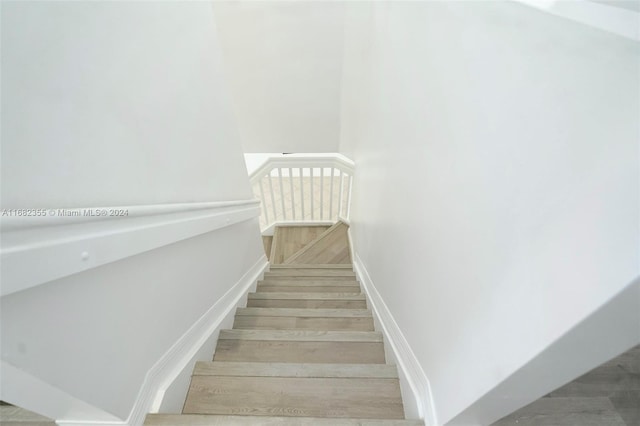 stairs featuring hardwood / wood-style floors