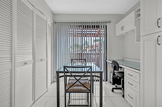 office area with light tile patterned floors and a textured ceiling